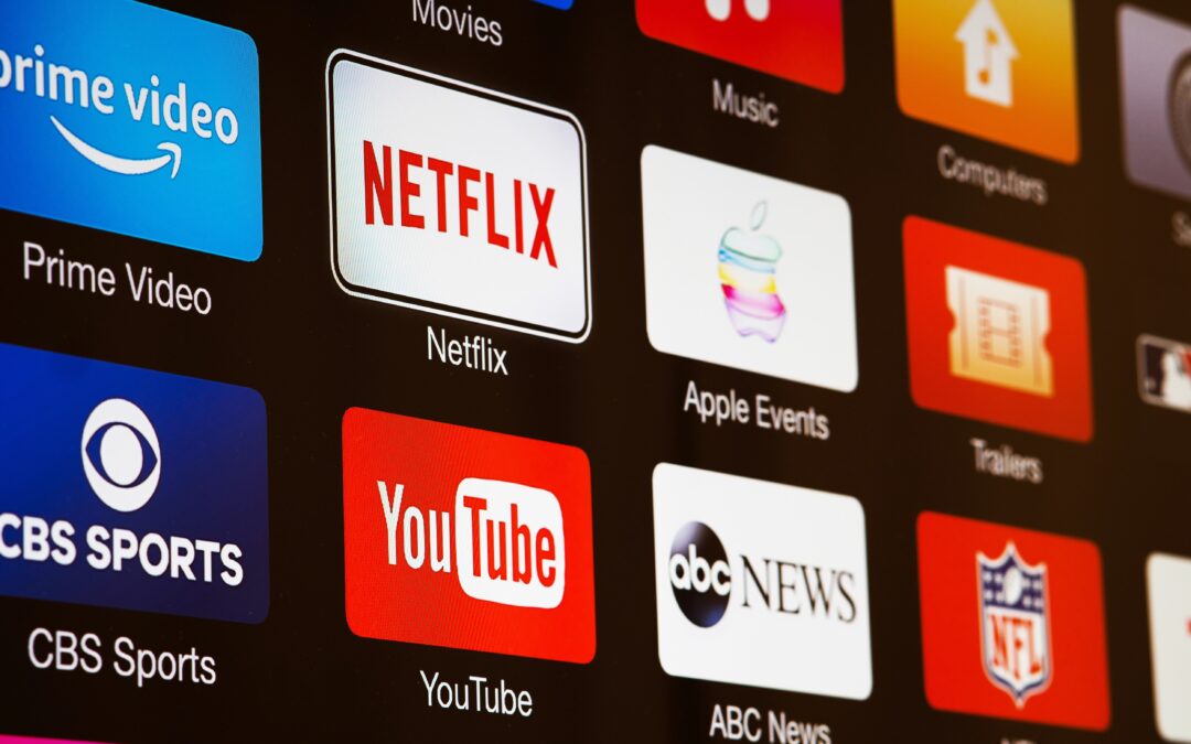 Ekran telewizora z ikonami platform streamingowych Netflix, YouTube i Prime Video – symbol binge watchingu i cyfrowego przeciążenia